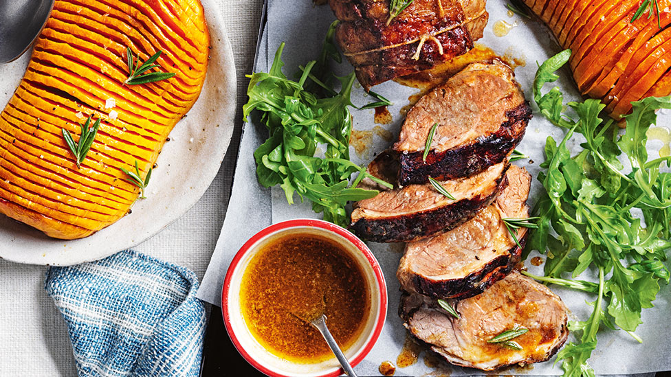 Sliced roast lamb served with hasselback pumpkin, rocket and dressing