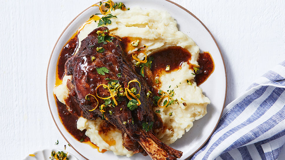 Lamb shank served on top of mashed potato with gremolata and lemon shavings