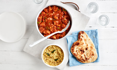Butter Chicken, Rice and Naan Bread laid out on table