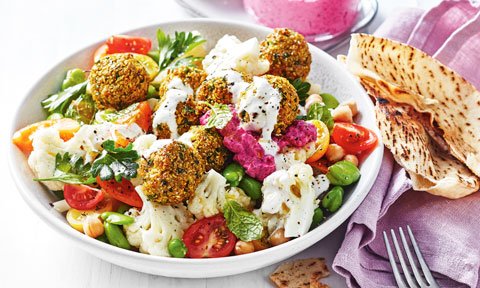 Cauliflower and Falafel Salad Bowl dressed in yoghurt, served with pita bread on lavender cloth