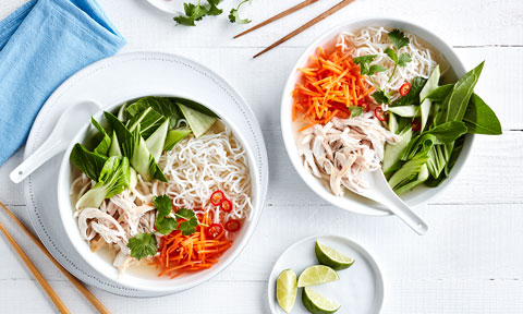 Easy Chicken Pho in two serving bowls with lime wedges to serve
