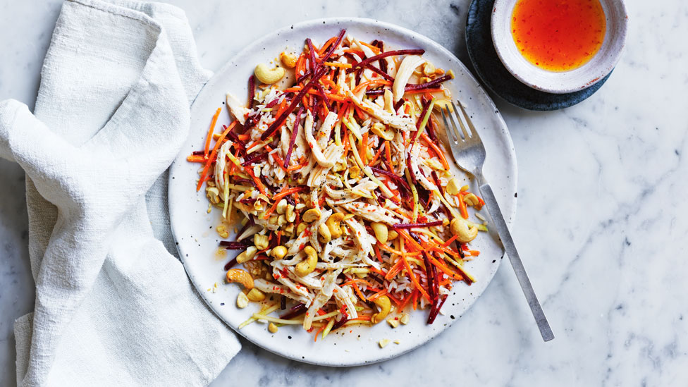 Chilli Chicken and Cashew Rice Salad on a plate, with a side bowl of chilli sauce