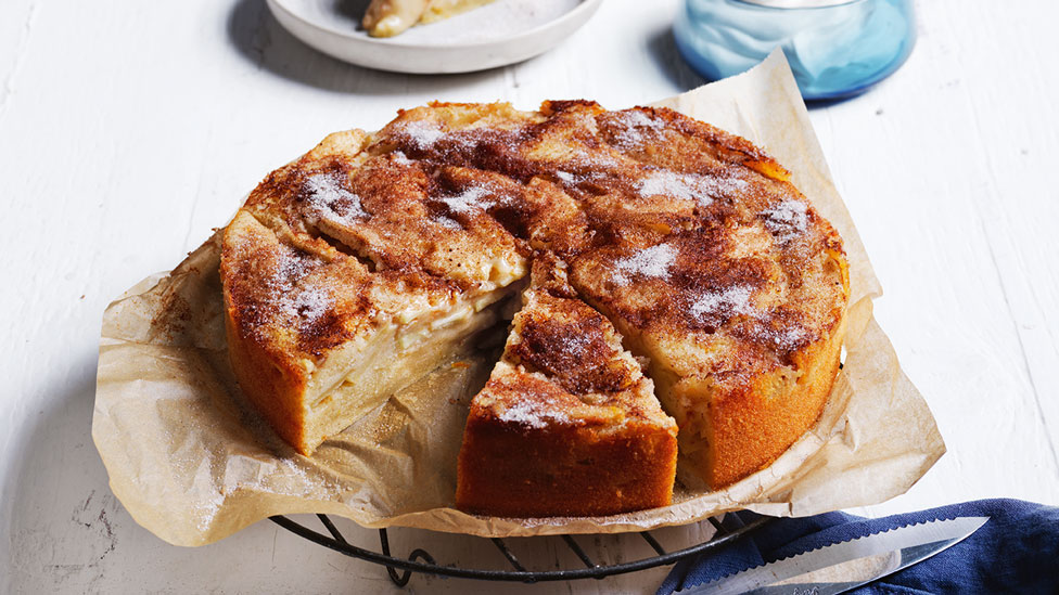 Curtis Stone's Apple Cinnamon Custard Cake on baking paper on a cooling tray