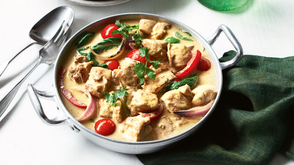 Green Chicken Curry in metal dish, placed on top of green cloth