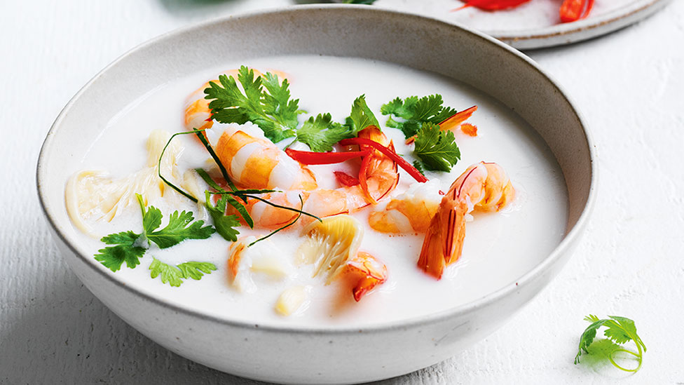A bowl of Thai Coconut Soup with Prawns, garnished with flat leaf parsley