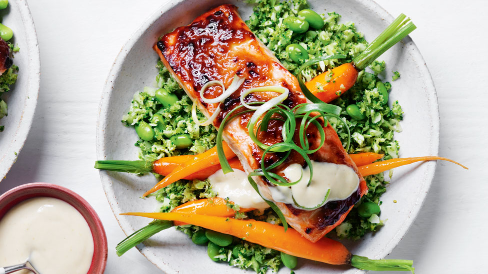 Miso salmon served on top of broccoli rice garnished with spring onion and wasabi mayo