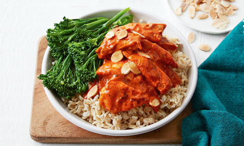 Butter Chicken with Baby Broccoli served with rice in a bowl, topped with almond flakes