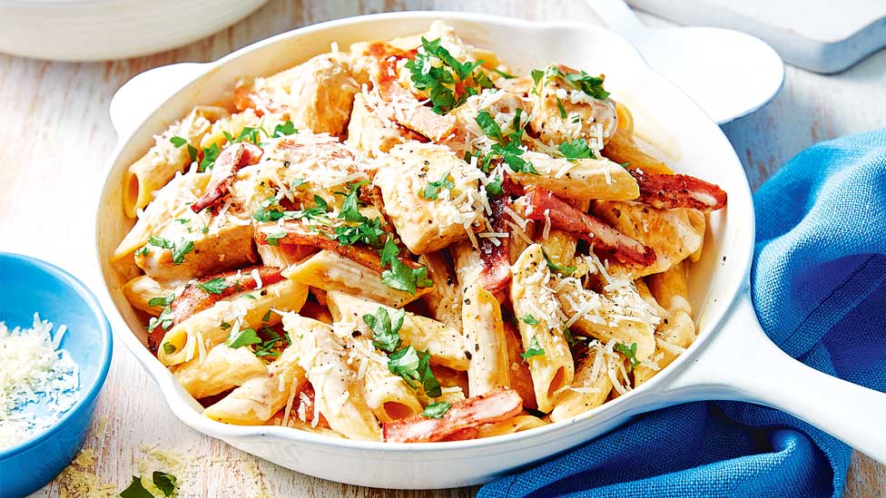 A bowl of creamy chicken carbonara with cheese and parsley