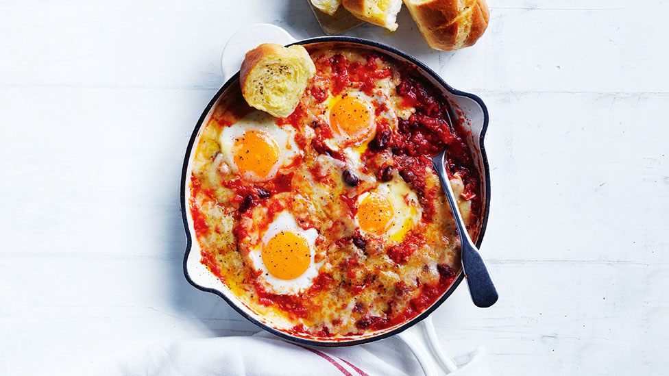 Four baked eggs with Mexican mixed beans and garlic bread