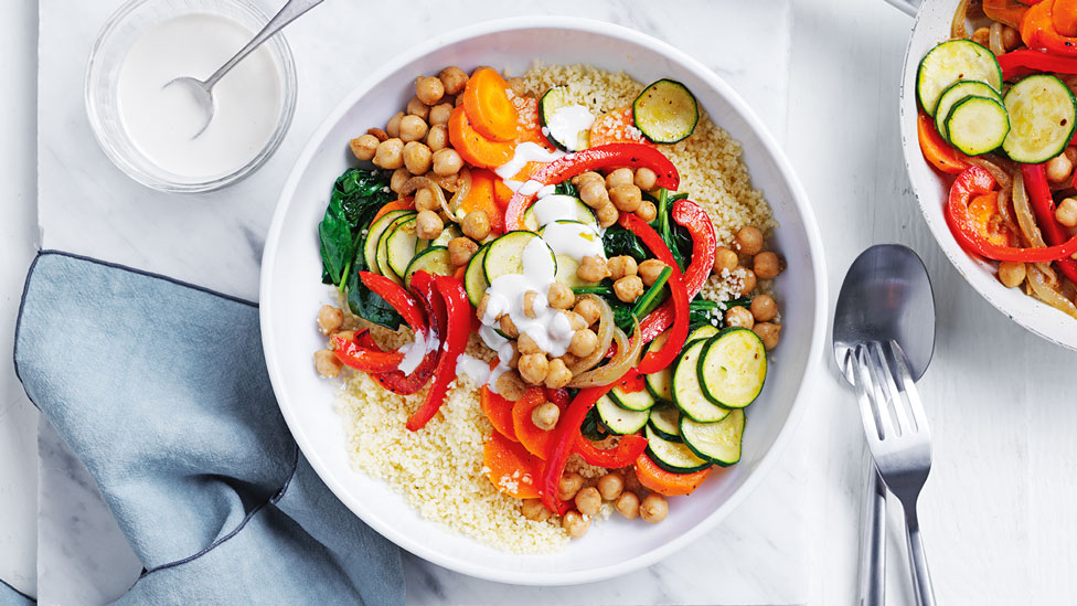 Vegan chickpea stir-fry topped with tahini dressing and couscous