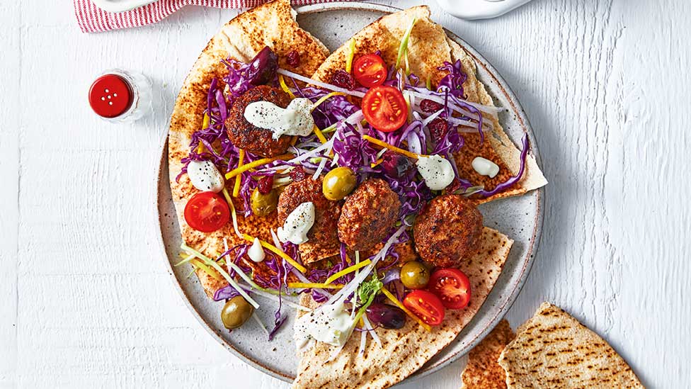 A stack of pita bread with beef meatballs served with salad