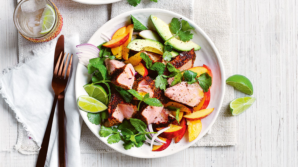 Blackened salmon with peach salad and lemon wedges