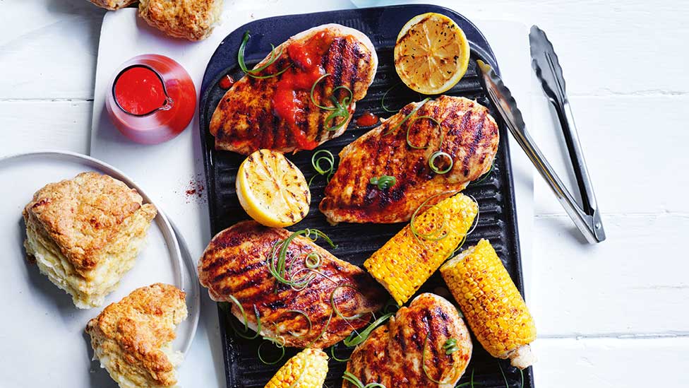 Four smoked BBQ chicken fillets with charred corn and hot sauce