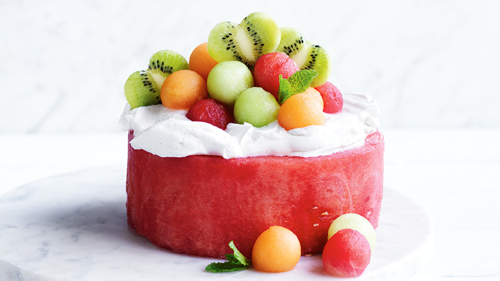 A watermelon cake topped with yoghurt and melon balls