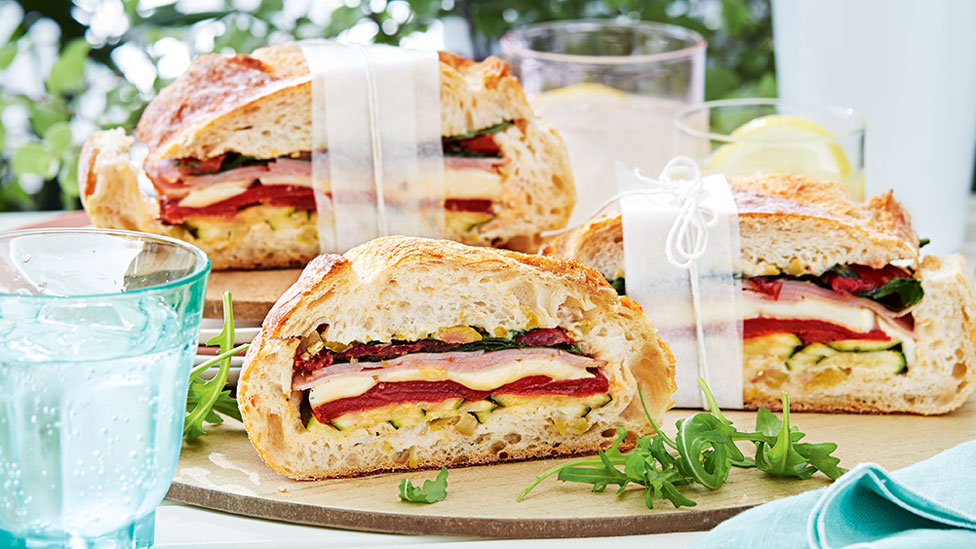 An open picnic sandwich with bocconicini, ham and veggies 