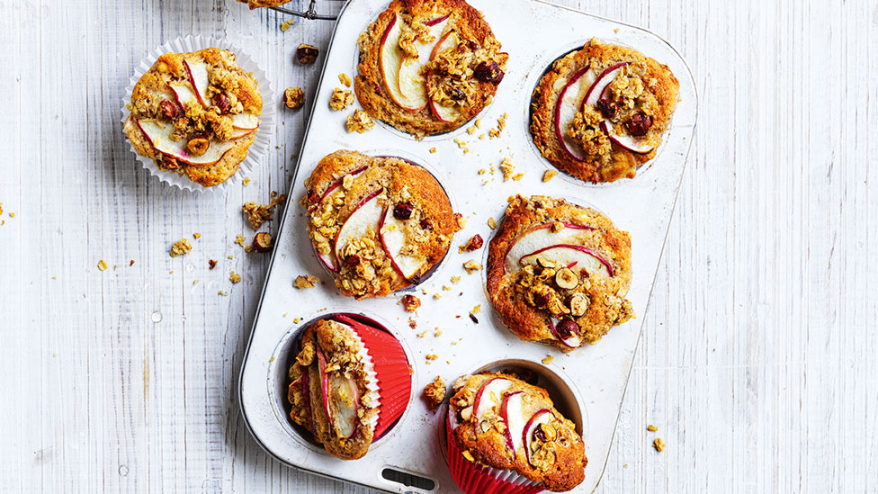 Nectarine and hazelnut muffins served in a muffin tin with one muffin on the side