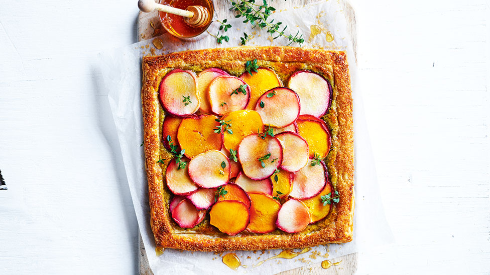 A square stone fruit galette topped with mint