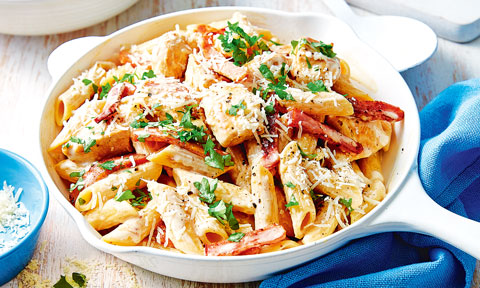 A bowl of creamy chicken carbonara with cheese and parsley
