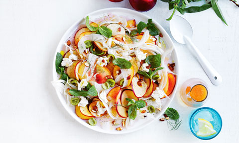A bowl of Pickled nectarine, fennel and goat’s cheese salad with dressing
