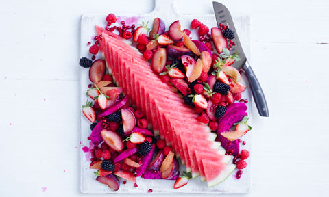 Pink fruit platter on a white chopping board