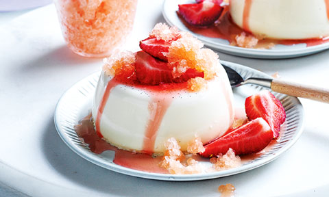A vanilla panna cotta topped with strawberries and aperol ice