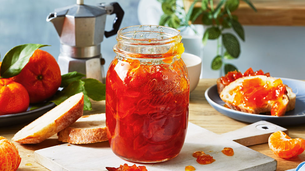 A jar of vibrant mandarin and ginger marmalade.