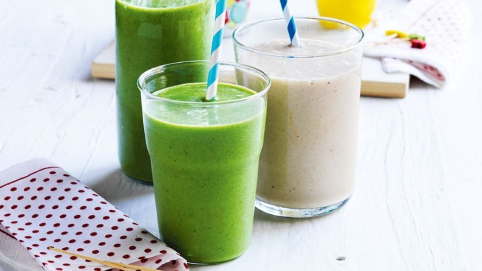 Three glasses of breakfast smoothies served on a chopping board