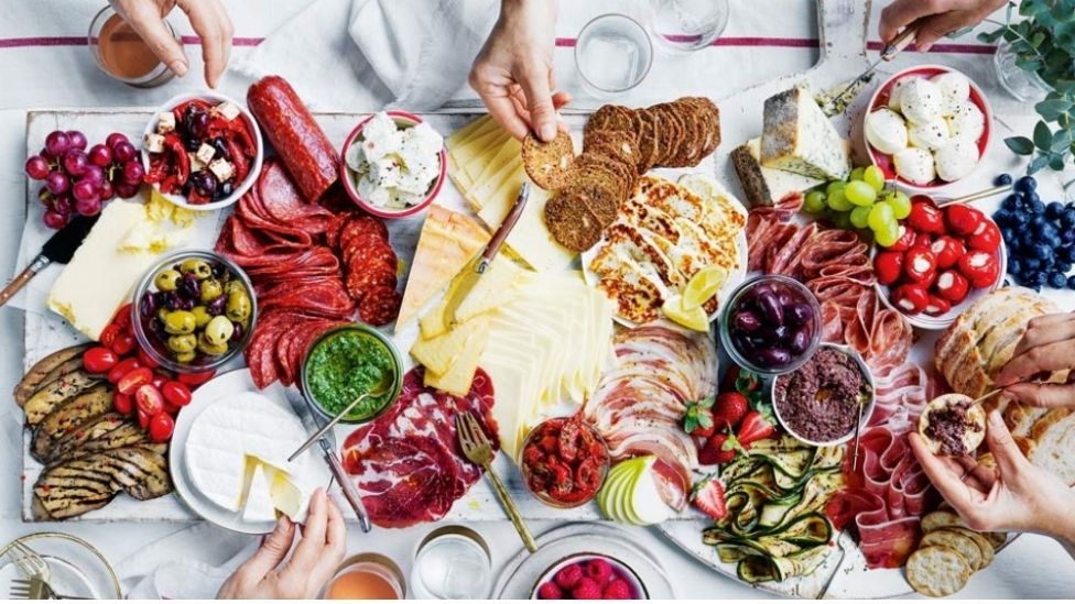 Big cheese board with assorted meats and fruit.