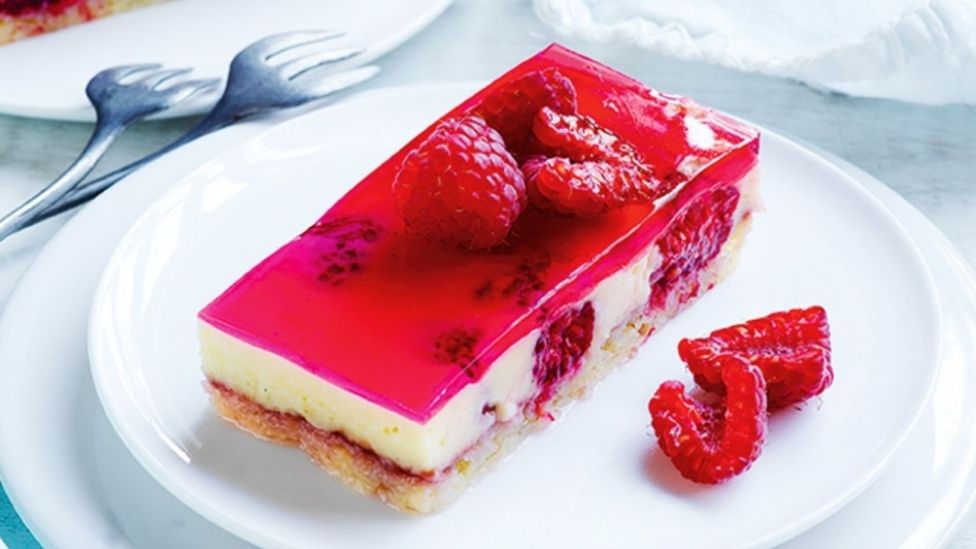 Raspberry trifle jelly slice decorated with sliced raspberries