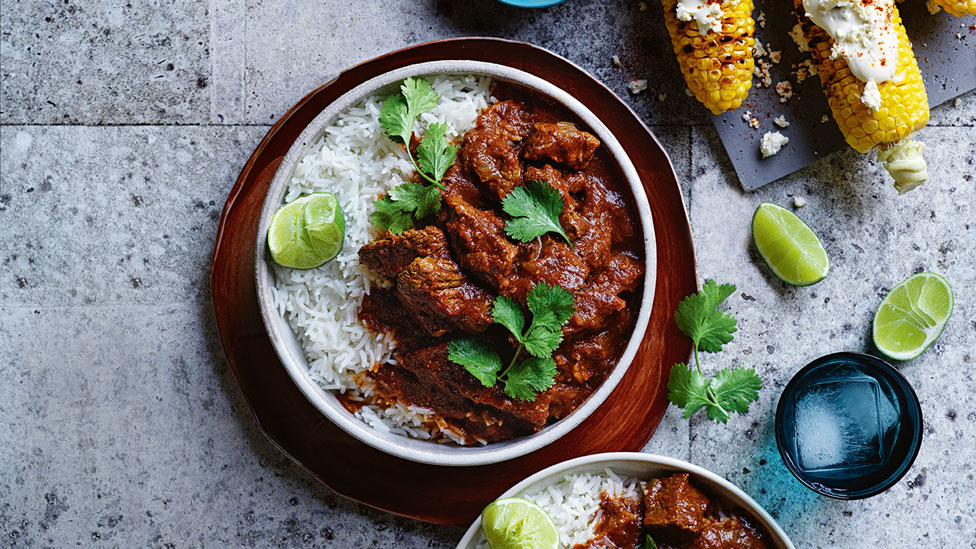 Mexican-style chilli beef stew with street corn and lime wedges
