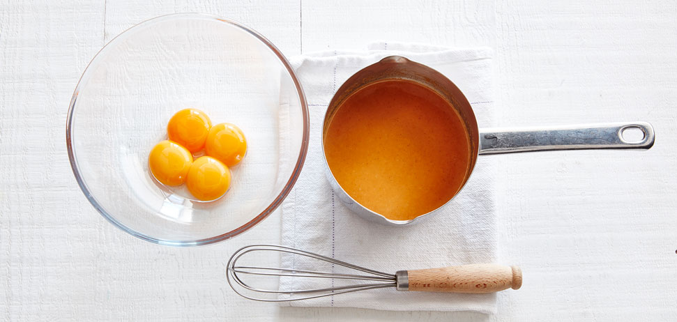 A pot with egg and whisk