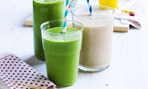 Three glasses of breakfast smoothies served on a chopping board