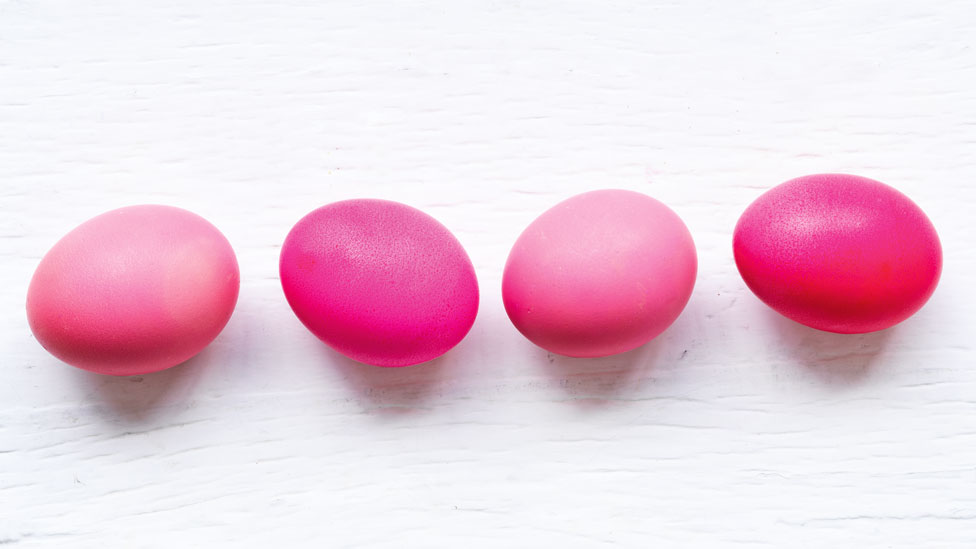 Four eggs dyed various shades of pink