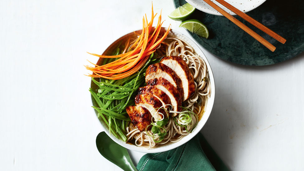 A bowl of spicy chicken ramen with garnishes