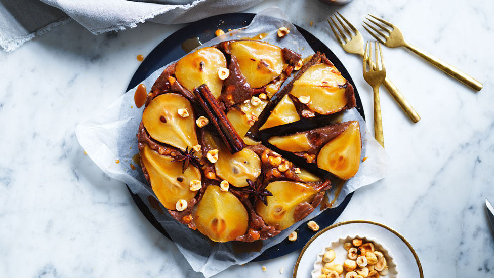 Chocolate and hazelnut upside-down pear cake cut into wedges