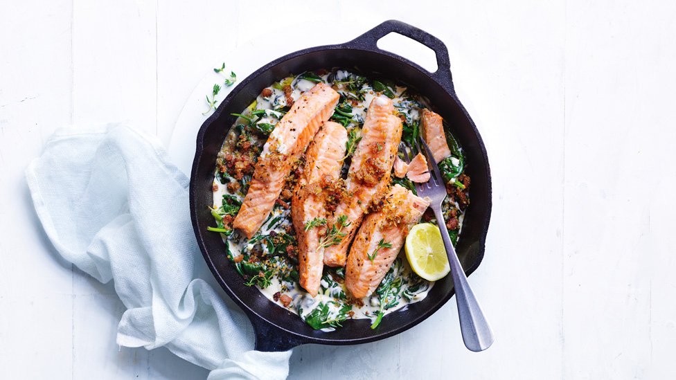 Salmon with bacon crumb, creamed spinach and lemon wedges