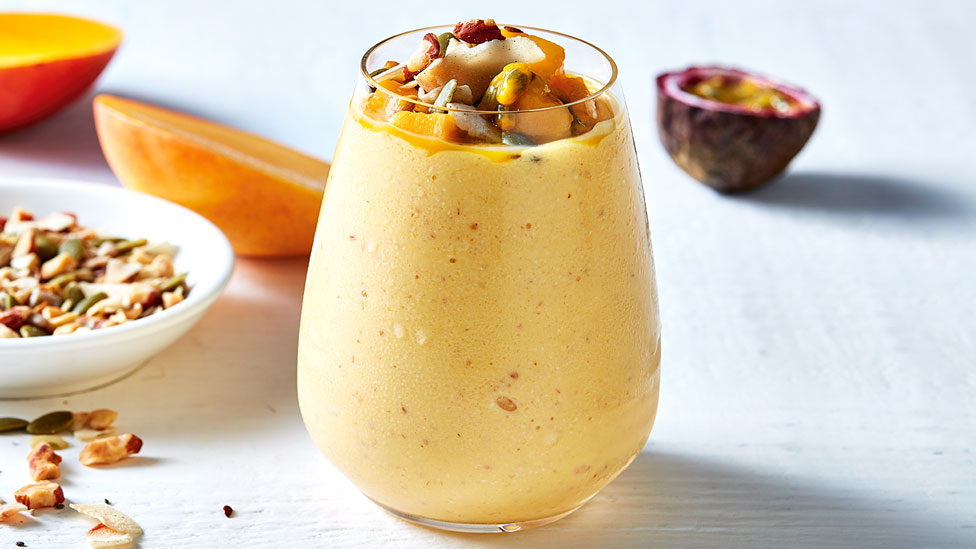 A cup of tropical mango and almond smoothie