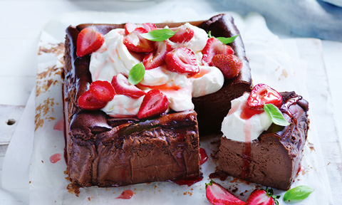 A basque chocolate cheesecake with cheese and roated strawberries on top