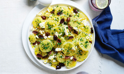 Peeled potatoes sprinkled with fetta and olives
