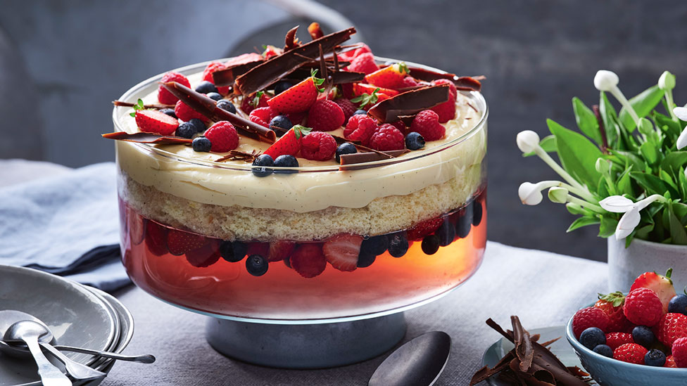 A jelly, sponge and cream trifle in a glass container