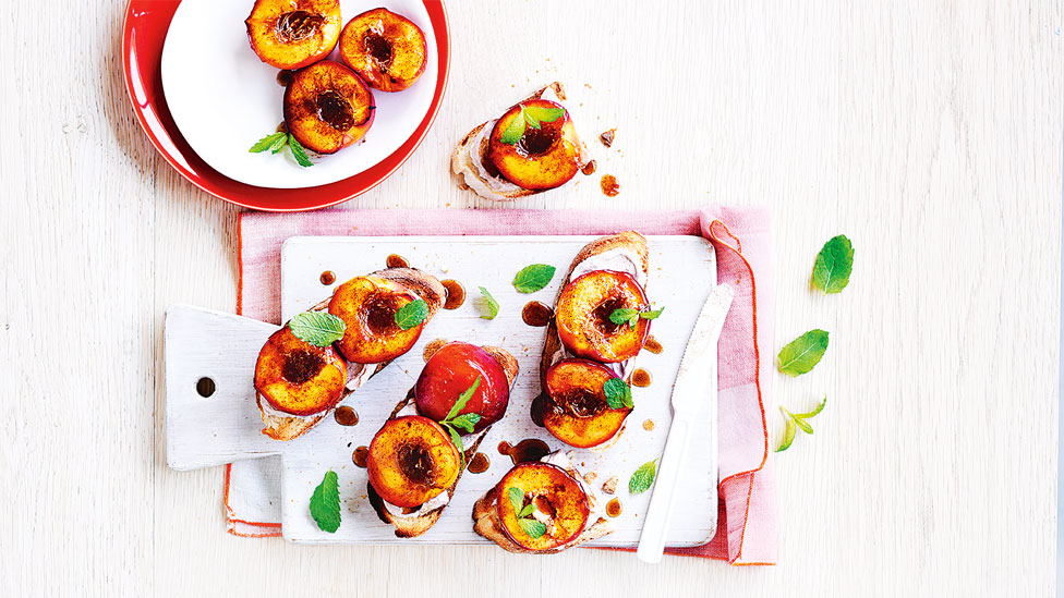 Fresh nectarine bruschetta on serving dishes, garnished with mint leaves. 