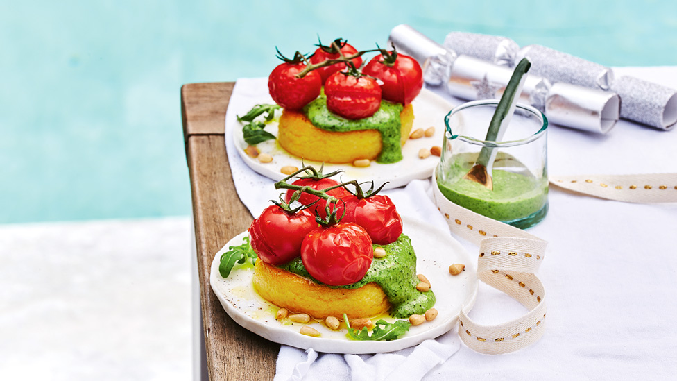 Two dishes of fried Polenta with creamy pesto and topped with roasted tomatoes