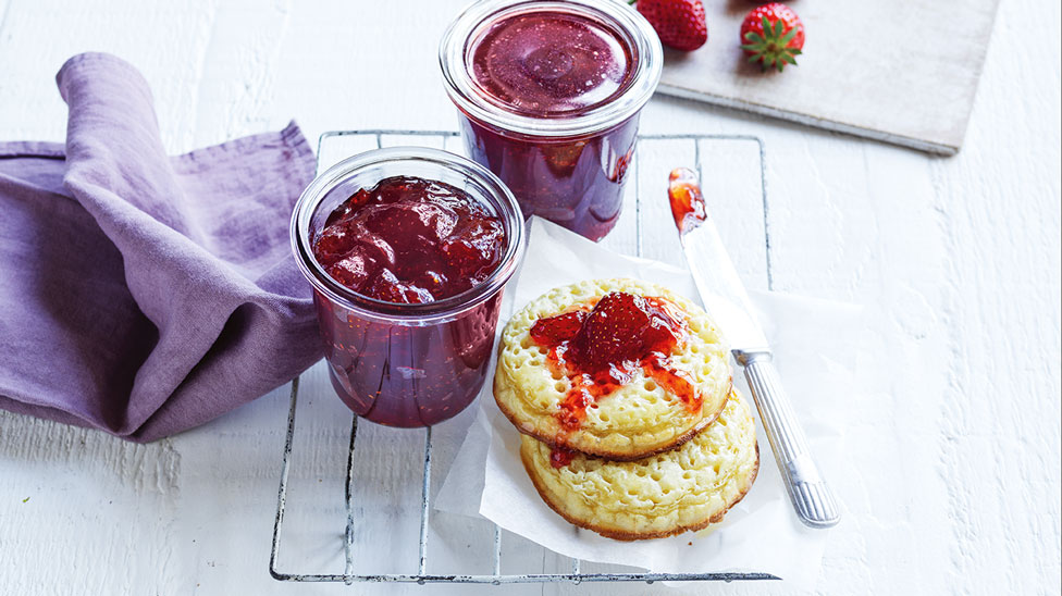 Two pots of home made strawberry jaw served with crumpets