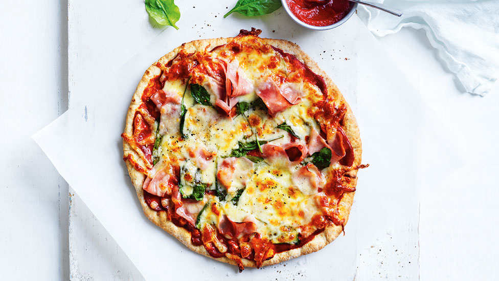 A spinach and ham pizza