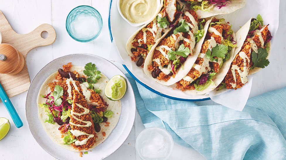 Crunchy chicken tacos served with rice, sour cream and limes