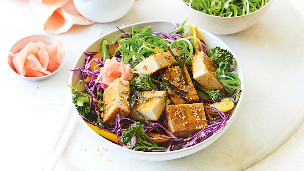 A bowl of japanese tofu salad served with pink ginger