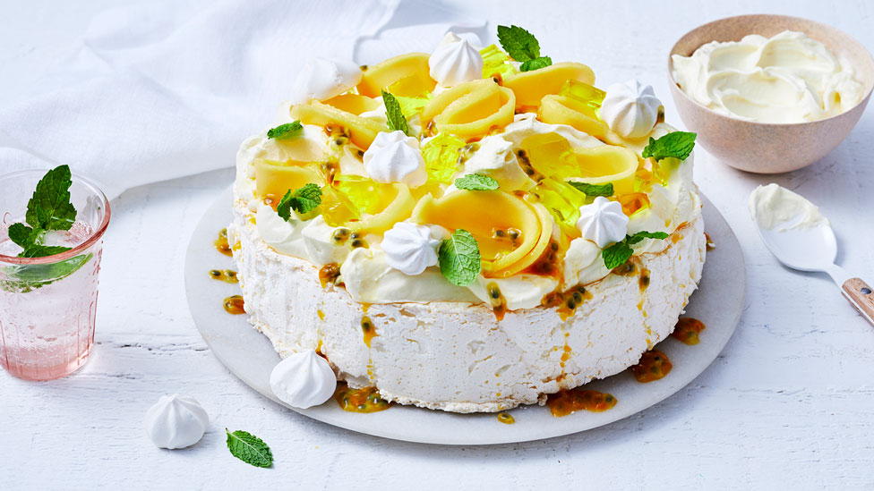 Tropical pavlova topped with mango, jelly and meringues