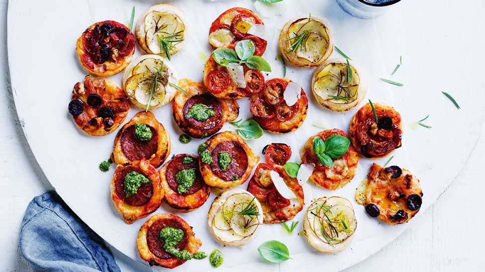 A table covered in mini antipasto pizzas