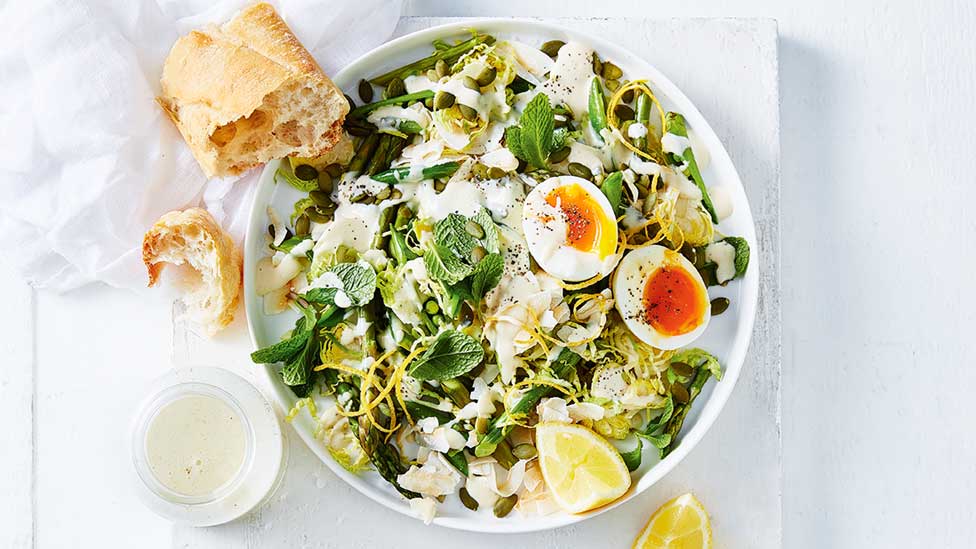 Green salad with egg cut in half and shredded brussel sprouts