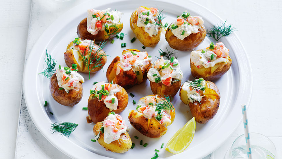 A plate of mini jacket potato loaded with sour cream and chives